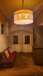 uma sala de estar com um sofá e um grande lustre em Orbeliani Hostel em Tbilisi
