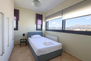 a bedroom with a bed and a large window at Thea Apartment_Athens Airport in Spáta