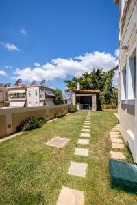 a backyard with grass and stones in the yard at Thea Apartment_Athens Airport in Spáta