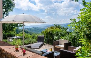 a patio with a table with an umbrella and chairs at Amazing Home In Mergo With House A Panoramic View in Mergo