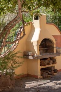 un horno de pizza sentado en el lateral de un edificio en Delizioso appartamento nel Golfo di Orosei con veranda, en Cala Liberotto