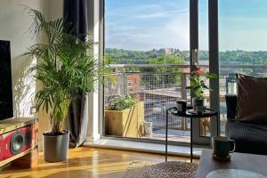 a living room with a large window with plants at Spacious Private Flat in Sheffield City Centre in Sheffield