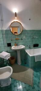 Un baño con lavabo, inodoro y espejo. en B&B Villa Margherita, en Lesa 31 fotos más