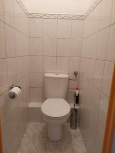 een badkamer met een toilet in een betegelde kamer bij Apartament Kolberga II in Sopot