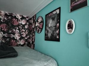 a bedroom with a bed and three pictures on the wall at DobraNoc in Łódź