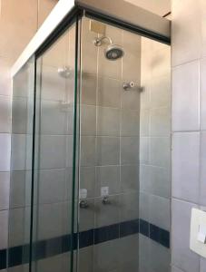 a shower with a glass door in a bathroom at FLAT ECONÔMICO E ACONCHEGANTE, 1Qt, sala e cozinha, Centro-GO in Goiânia