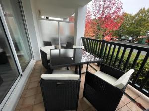 porche acristalado con mesa y sillas en el balcón en Appartement dans résidence au calme, en Bayona