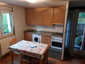 a small kitchen with a table with a book on it at El Lagar in Aller