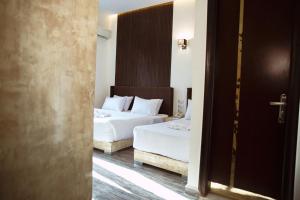 a hotel room with two beds and a doorway at Tourist Palace Hotel in Cairo