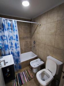 Departamento Centrico San Martin في سان سلفادور دي خوخوي: حمام مع مرحاض وحوض استحمام ومغسلة