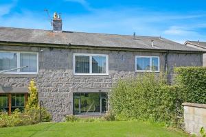 uma casa de pedra com um cão em cima dela em Faulds Crescent Lodge ✪ Grampian Lettings Ltd em Aberdeen