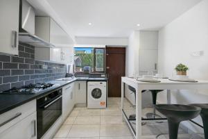 uma cozinha com um fogão, um lavatório e uma máquina de lavar louça em Faulds Crescent Lodge ✪ Grampian Lettings Ltd em Aberdeen