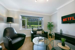 uma sala de estar com duas cadeiras e uma mesa em Faulds Crescent Lodge ✪ Grampian Lettings Ltd em Aberdeen