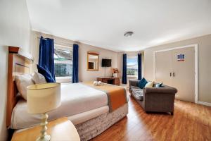 倫敦德里的住宿－愛奧納旅館，一间卧室配有一张床、一张沙发和一把椅子