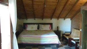een slaapkamer met een groot bed en een bakstenen muur bij Casa Matisa in Rivera