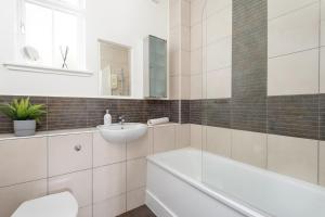 een badkamer met een wastafel, een bad en een toilet bij The Tron Square Residence in Edinburgh