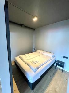 a small bedroom with a bed and a chair at Modern Apartment With Hot Tub in Akureyri in Akureyri