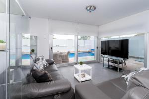 een woonkamer met een bank en een tv bij Villa near the sea in Pilar de la Horadada