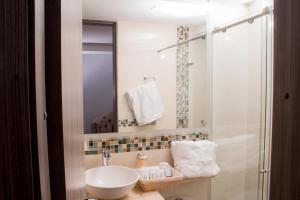 a bathroom with a white sink and a shower at ALESOMAYA APARTHOTEL in Cali