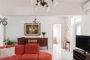 een woonkamer met een rode bank en een tv bij Casa Valore in Chania