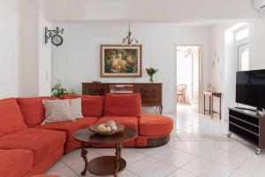 een woonkamer met een rode bank en een tafel bij Casa Valore in Chania