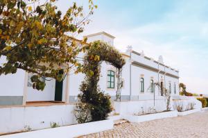 a white building with a tree in front of it at Cerca Velha - Country House in Albufeira