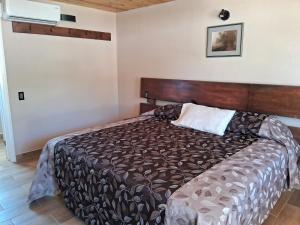 een slaapkamer met een groot bed met een houten hoofdeinde bij Villas la Quinta (etapa Aserradero) in Creel