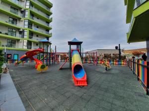 um parque infantil com diferentes equipamentos de brincar de cor num edifício em Andreas - Pool & Spa Beach Resort em Mamaia Nord – Năvodari