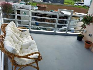 a wicker chair sitting on top of a balcony at Ospede Luscofusco Carballo-Costa da Morte in Carballo