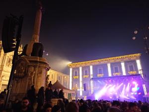 una folla di persone che si trovano di fronte a un edificio di notte di Sogno Etneo a Catania