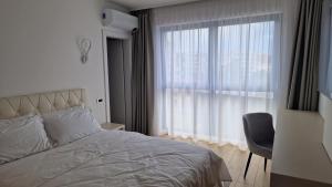 a bedroom with a bed and a large window at Valentini Apartments in Cluj-Napoca