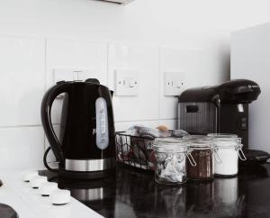 a kitchen counter with a tea kettle and jars on it at The Minimalist - Entire 1 bed flat near Gunwharf Quays, Ground Floor Flat Private Entrance in Portsmouth