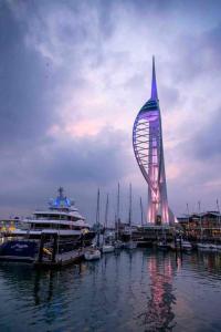 a ferris wheel and a cruise ship in a harbor at The Minimalist - Entire 1 bed flat near Gunwharf Quays, Ground Floor Flat Private Entrance in Portsmouth