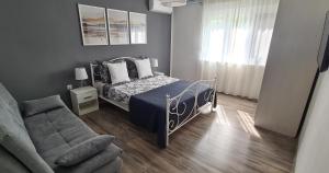 a bedroom with a bed and a couch at Levante - 500m Amphitheatre - free parking in Pula +14 photos