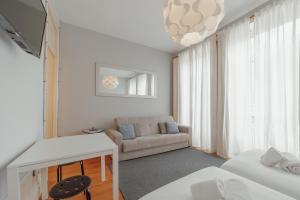 a white living room with a couch and a table at OPORTO GUEST Moinho de Vento Studios in Porto