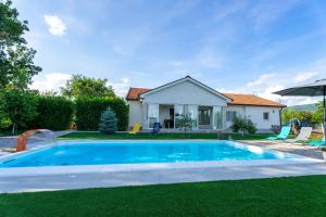 a swimming pool in front of a house at Holiday home Carpinus in Široki Brijeg