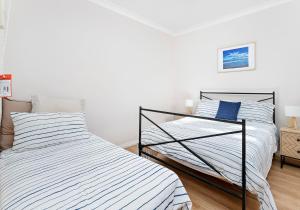 two beds sitting next to each other in a bedroom at Cosy cottage by the sea in Gerroa