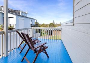 a pair of chairs sitting on a balcony at Cosy cottage by the sea in Gerroa