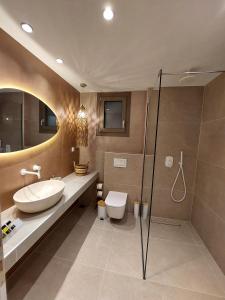 a bathroom with a sink and a toilet and a shower at Phoenix Apartments Parga in Parga