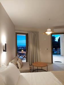 a bedroom with a bed and a table and some windows at Phoenix Apartments Parga in Parga