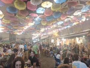 una folla di persone sedute in una stanza con ombrelloni sul soffitto di Sogno Etneo a Catania