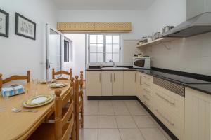 cocina con mesa de madera con sillas y fregadero en Casa Vlaorda by HH en Caleta de Sebo
