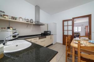 eine Küche mit einem Waschbecken und einem Tisch darin in der Unterkunft Casa Vlaorda by HH in Caleta de Sebo