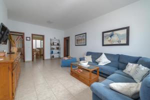 uma sala de estar com um sofá azul e uma mesa em Casa Vlaorda by HH em Caleta de Sebo