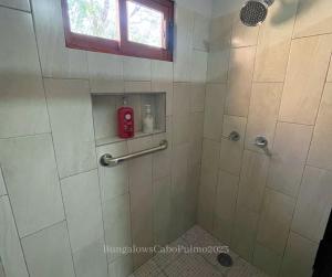 a bathroom with a shower with a red fire extinguisher at Bungalows Cabo Pulmo in Cabo Pulmo