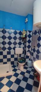 uma casa de banho com um piso xadrez azul e branco em A&K Sea view apartament 7 em Durrës