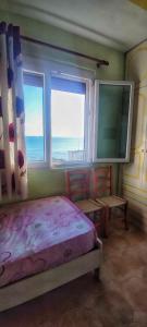 um quarto com uma cama, 2 cadeiras e uma janela em A&K Sea view apartament 7 em Durrës