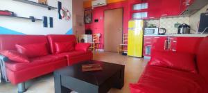 uma sala de estar com um sofá vermelho e uma cozinha em A&K Sea view apartament 7 em Durrës