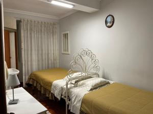 a bedroom with two beds and a clock on the wall at Residencia do Norte in Lisbon