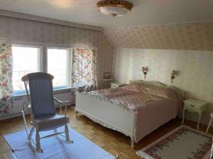 1 dormitorio con 1 cama, 1 silla y 2 ventanas en Family house 150m2 in Kauhava down town en Kauhava